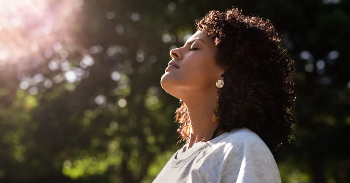 Employee practicing mindfulness in the workplace during her lunch break in a park.