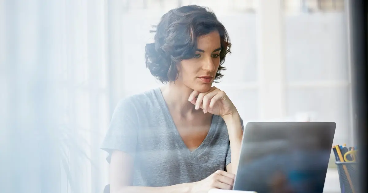 Woman researching onsite wellness solutions on a laptop.