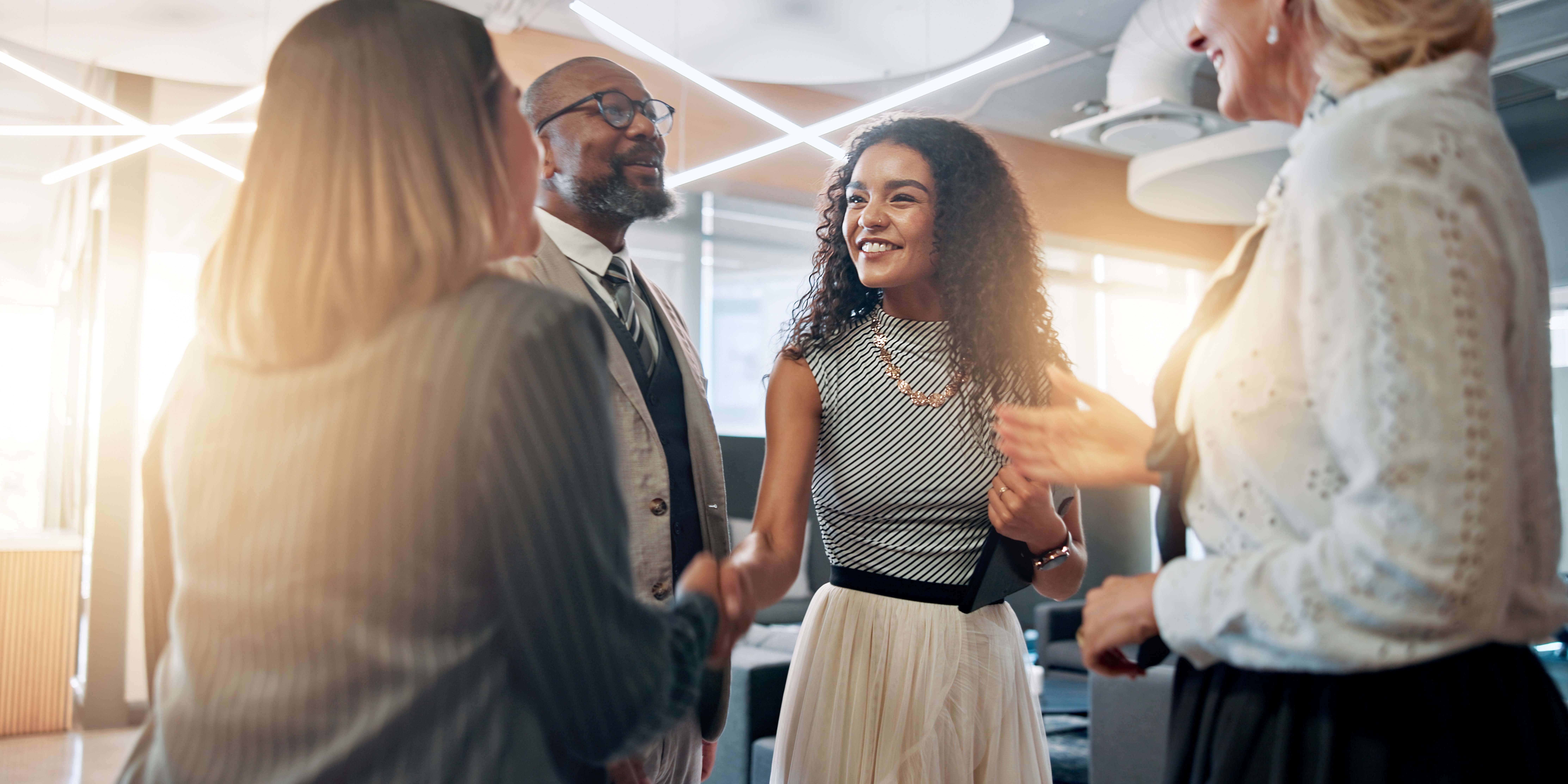 People shaking hands in a corporate office setting