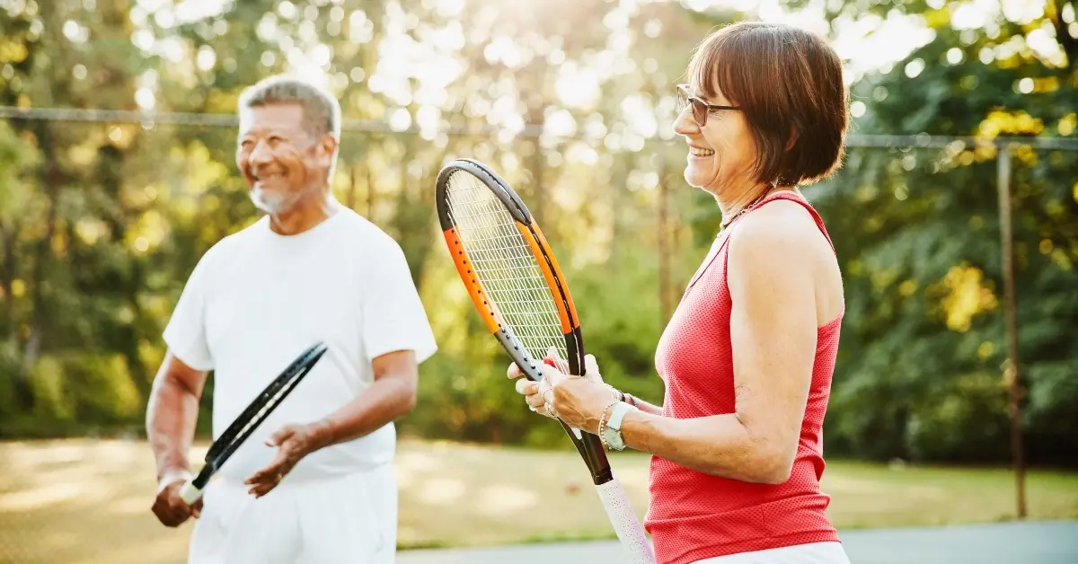 Physically healthy employees playing tennis outside of work.